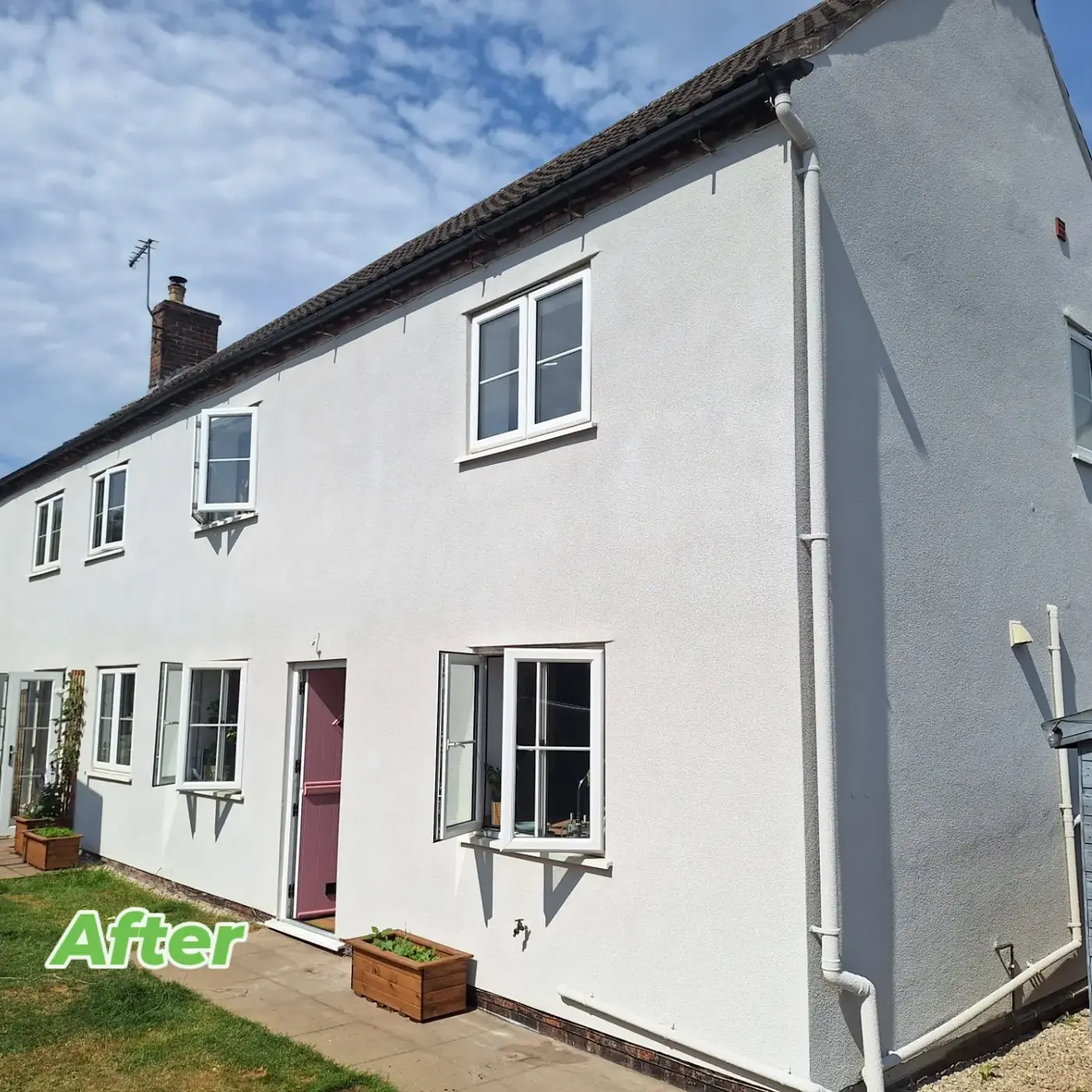 Cottage after: clean white SprayCork finish across the whole elevation